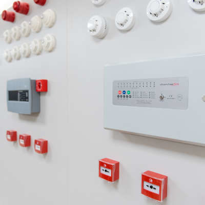types of Fire Alarms displayed on a wall, with fire panels