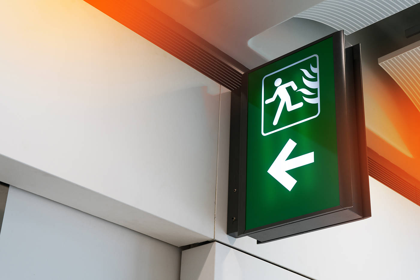 Emergency lighting, illuminated green fire exit signs, in a public building