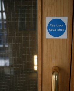 a fire door with a fire safety sign attached saying fire door keep shut
