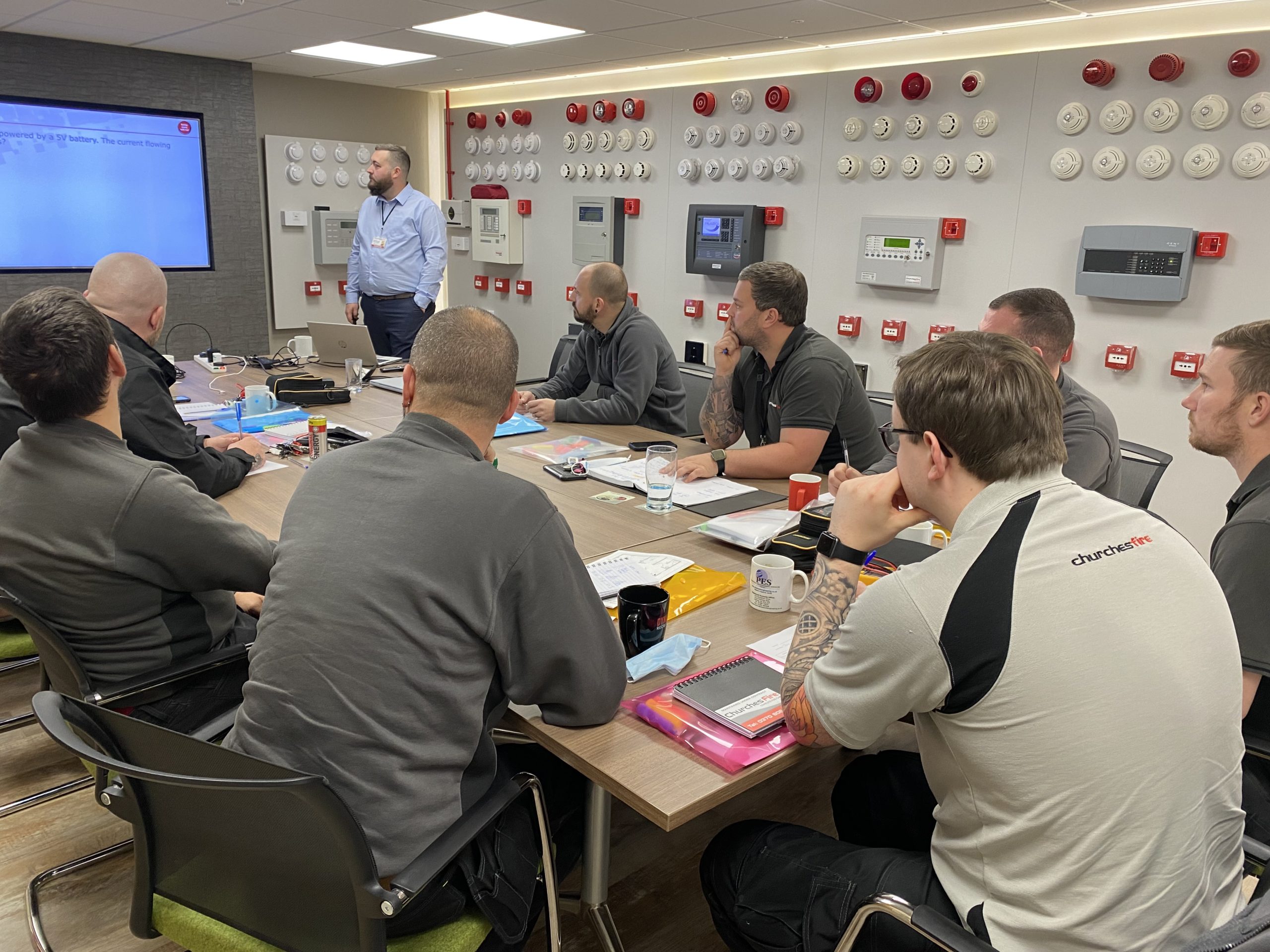 a group of men in front of a presentation for the Churches Fire training academy session